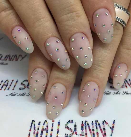 Small rhinestones and a neutral shade in the manicure