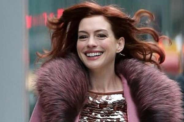 Anne Hathaway insulated with taste: a winter coat, sequins and a bright skirt