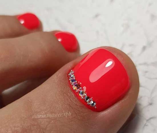 Bright coral pedicure with rhinestones