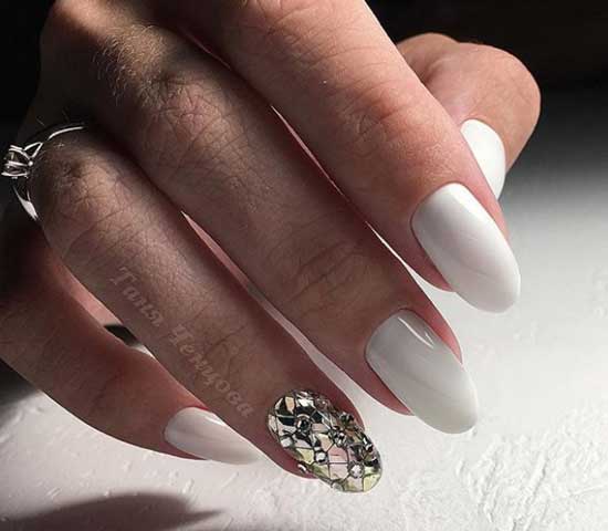 Manucure blanche comme neige et strass sur un seul ongle