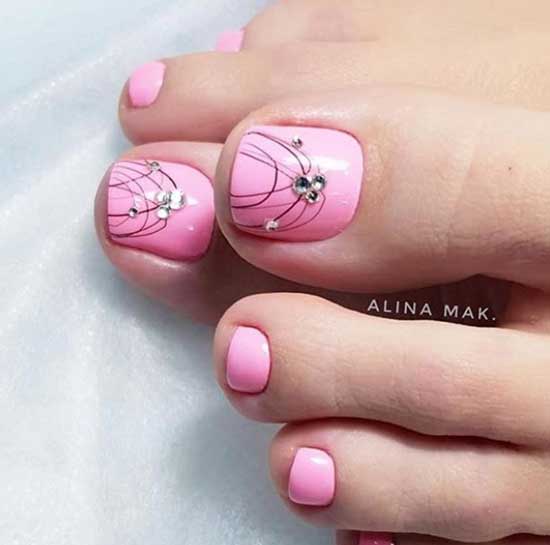 Pink pedicure with rhinestones and spider web design