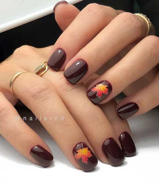 Manicure with a yellow autumn leaf