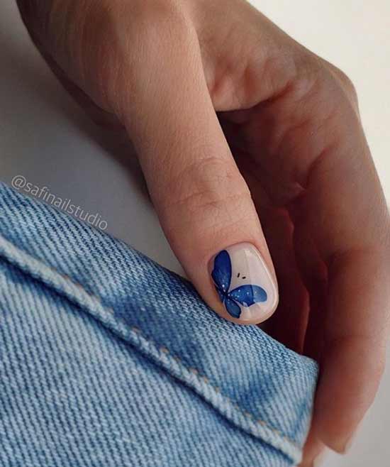 Photo d'ongles avec un papillon bleu