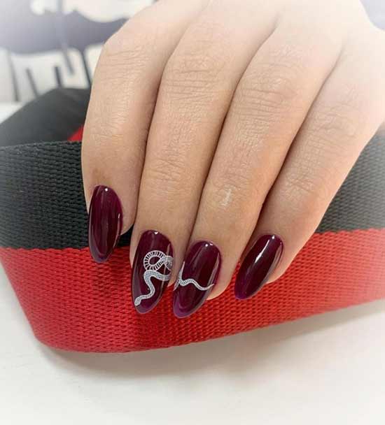 Burgundy manicure with a snake