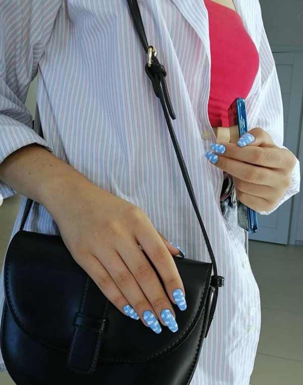 Blue manicure and white clouds