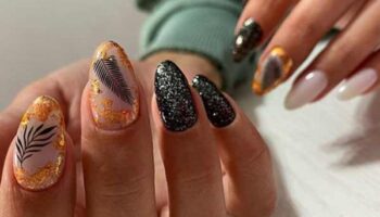 Stylish black manicure with sparkles in the photo