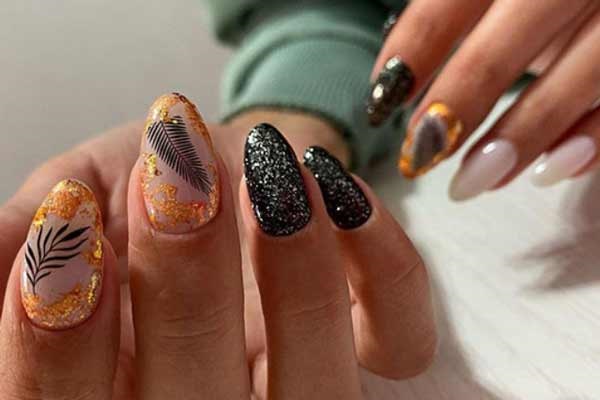 Stylish black manicure with sparkles in the photo