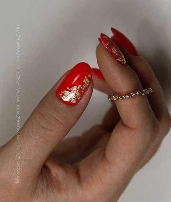 Red manicure with gold leaf