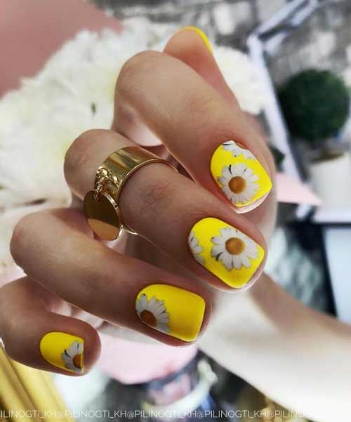 Yellow manicure with daisies